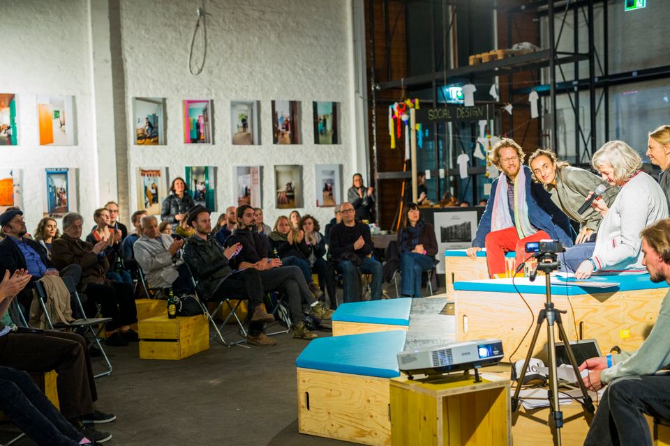 urbanize! Festival 2018 in der Nordbahnhalle. Im Hintergrund die Ausstellung Wir anderen von Kati Bruder. Am Podium v.l.n.r. Florian Schmidt (Baustadtrat, Bezirk Friedrichshain-Kreuzberg, Berlin), Maria Muñoz Duyos (Urbanitas Berlin Barcelona), Elke Rauth und Ivana Pilic (Kuratorinnen urbanize). Foto — Lena Kuzmich